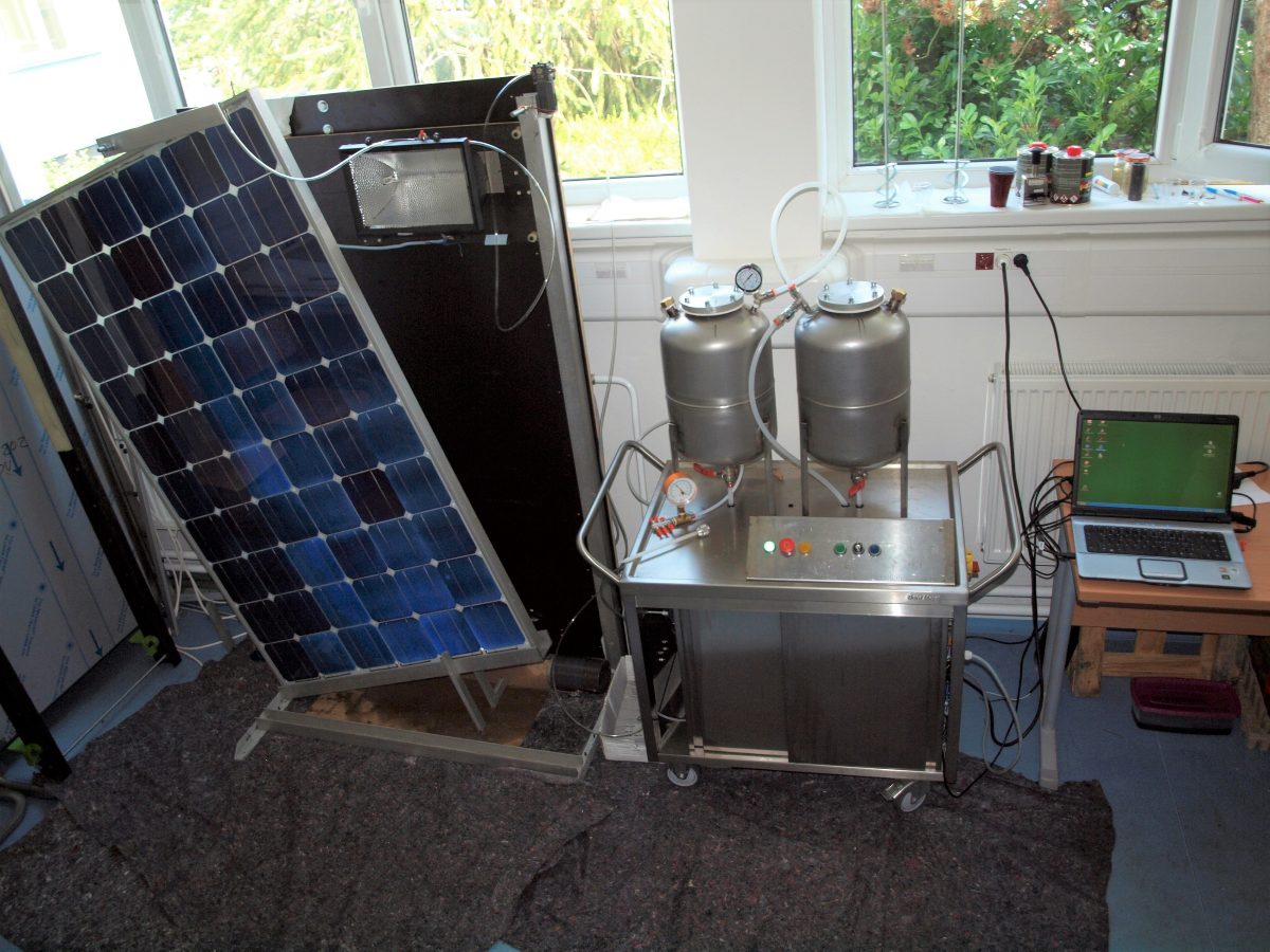 Silicone gel encapsulation laminator in use beside a PV panel and a laptop reading out the process — room-temperature lamination in the workshop.